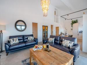 a living room with leather couches and a wooden table at Moorgate Lodge - Uk47742 in Kelbrook