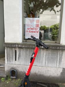 a scooter leaning against a building with a sign on it at Vintage Lovers Antwerp in Antwerp
