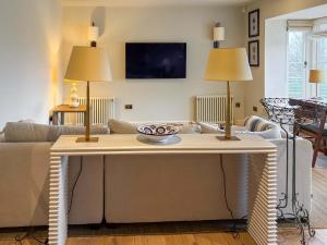 a living room with a couch and a table with two lamps at Cairn Ryan in Saint Mawes +17 photos