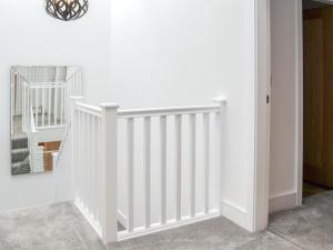 a white staircase in a room with a mirror at Linden Manor in Bridlington
