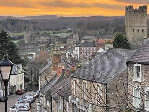 a city with cars parked on a street with a castle at Millgate Fosse Cottage in Richmond
