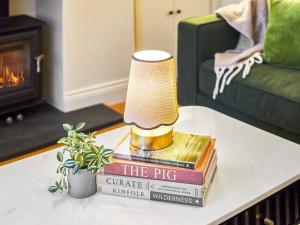 a lamp sitting on top of books on a coffee table at Hovera Cottage in Windermere