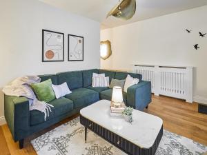 a living room with a blue couch and a table at Hovera Cottage in Windermere