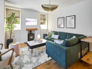 a living room with a blue couch and a fireplace at Hovera Cottage in Windermere