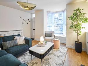 a living room with a blue couch and a table at Hovera Cottage in Windermere