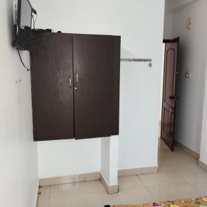 a black cabinet on a wall in a room at Sifa Guest House in Chennai