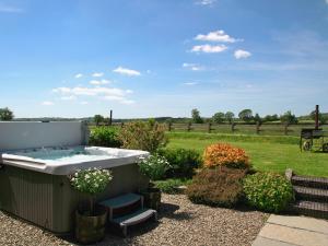 a hot tub in a garden with a field at Bwthyn Onnen-Oa5 in Ystrad Meurig +11 photos