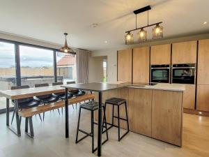 a kitchen with a table and a counter with stools at The Elms - Ukc4613 in Dunholme