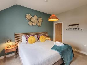 a bedroom with a large white bed with a green wall at The Elms - Ukc4613 in Dunholme +5 photos