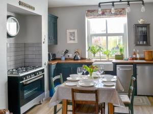 a kitchen with a table with chairs and a stove at Dick 'N' Liddy's in Gargrave