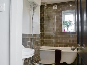 a bathroom with a tub and a toilet and a sink at Dick 'N' Liddy's in Gargrave