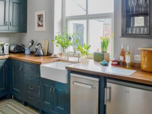 a kitchen with black cabinets and a white sink at Dick 'N' Liddy's in Gargrave