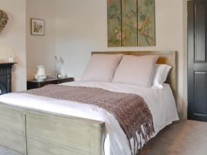 a bedroom with a large bed with white sheets and pillows at Dick 'N' Liddy's in Gargrave +8 photos
