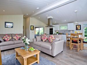 a living room with two couches and a table at Willow Lodge in Hassocks