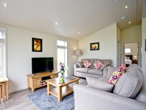 a living room with two couches and a flat screen tv at Willow Lodge in Hassocks +14 photos