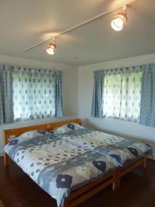 a bedroom with a bed with blue and white curtains at Sora-mame in Yakushima