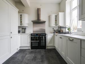 a kitchen with white cabinets and a black oven at Salt House - Uk43012 in Berkeley