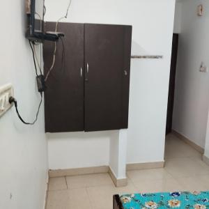 a kitchen with a black cabinet on the wall at Sifa Guest House in Chennai +24 photos
