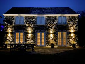 a stone house with a table in front of it at night at Barn Cottage in Saint Mawgan