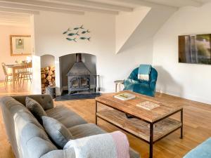 a living room with a couch and a table and a fireplace at Barn Cottage in Saint Mawgan +7 photos