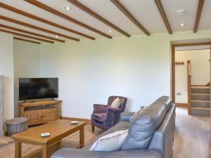 a living room with a couch and a tv at Deer Park - Uk33360 in Reeth