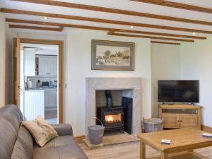 a living room with a couch and a fireplace at Deer Park - Uk33360 in Reeth
