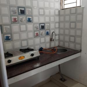 a kitchen counter with a sink and a stove at Sifa Guest House in Chennai