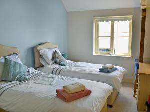 a bedroom with two beds with towels on them at Rose Cottage in Rillington