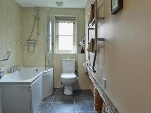 a bathroom with a toilet and a sink and a shower at Rose Cottage in Rillington