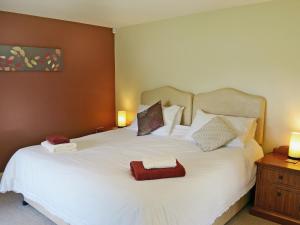 a bedroom with a white bed with two towels on it at Rose Cottage in Rillington +6 photos