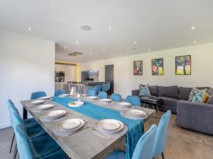 a dining room with a long table and blue chairs at The Old School House in Barnsley