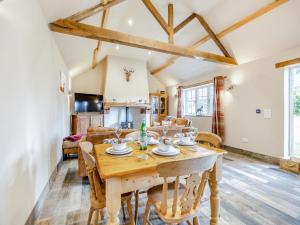 a kitchen and living room with a wooden table and chairs at The Old Stables in Cumberworth