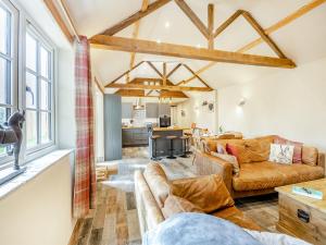 a living room with two couches and a kitchen at The Old Stables in Cumberworth