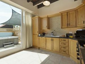 a kitchen with wooden cabinets and a large window at Church View - Ukc2302 in Wainfleet All Saints +16 photos
