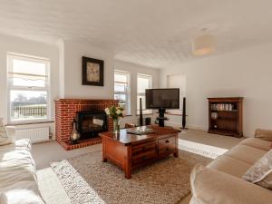 a living room with a couch and a fireplace at Highgrove in Gissing