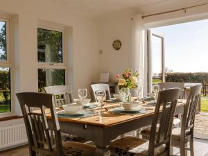 a dining room with a wooden table and chairs at Highgrove in Gissing