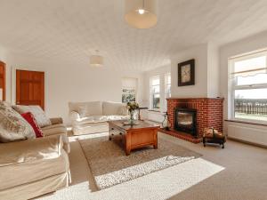 a living room with a couch and a fireplace at Highgrove in Gissing +13 photos