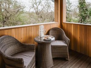 a porch with two chairs and a table and a window at Kiri - Uk51106 in Clitheroe