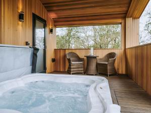 a hot tub on a deck with a table and chairs at Kiri - Uk51106 in Clitheroe