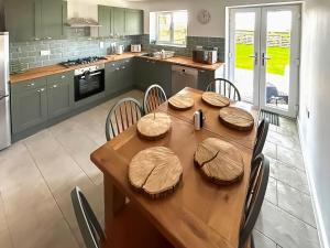a kitchen with a wooden table with chairs around it at No 4 Squirrels Nest-Uk44305 in Lenwade