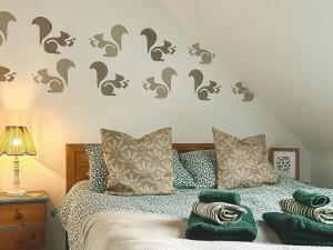 a bedroom with a bed with gray cats stenciled on the wall at No 4 Squirrels Nest-Uk44305 in Lenwade