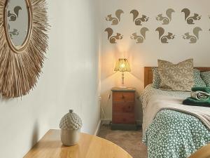 a bedroom with a bed and a table and a mirror at No 4 Squirrels Nest-Uk44305 in Lenwade