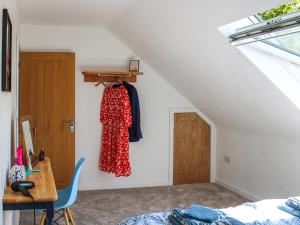 a bedroom with a bed and a dress hanging on a wall at No 4 Squirrels Nest-Uk44305 in Lenwade +9 photos