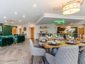 a dining room with a table and some green chairs at Fairview in Penicuik