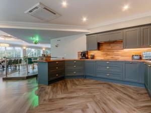 a kitchen with blue cabinets and a dining room at Fairview in Penicuik +26 photos