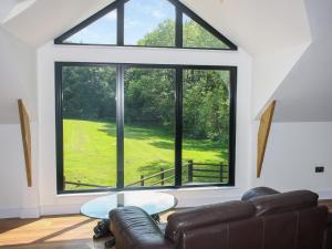 a living room with a couch and a large window at Foxton Barn - Uk47297 in Harrietsham