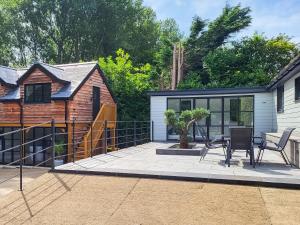 a house with a patio with chairs and a fence at Foxton Barn - Uk47297 in Harrietsham +12 photos