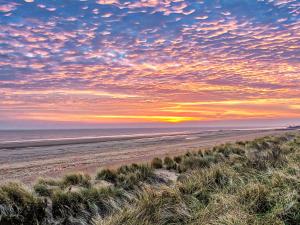 a beach at sunset with a cloudy sky at The Pastures - Uk41853 in Maltby le Marsh +25 photos