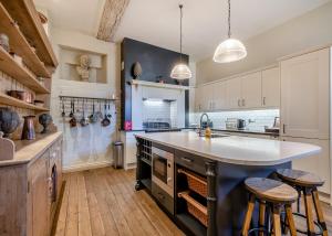 a large kitchen with a large island and two bar stools at Oxnead Hall in Brampton