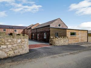 a brick building with a stone wall in front of it at Cor Tarw - Uk12743 in Acrefair +30 photos